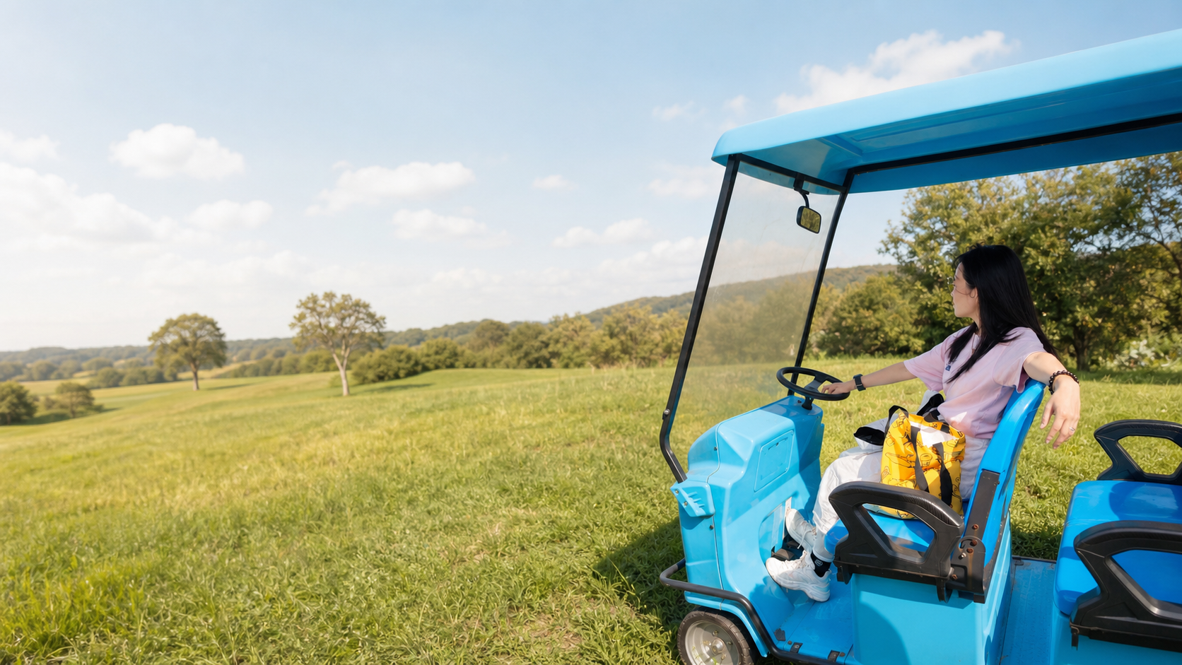 Celia resting in a blue farm cart and looking across an open green field